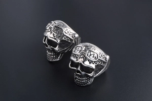 Detail view of two punk style vintage titanium steel skull rings with pilot goggles
