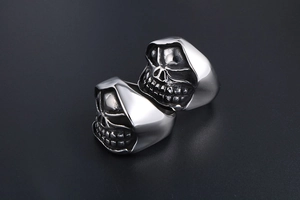 Detailed view of two skull rings with polished silver finish and gothic metal textures