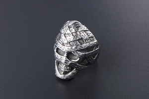 Macro shot of punk style mummy skull ring featuring vintage silver bandages and oxidized finish