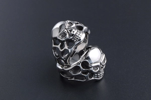 Macro shot of two vintage gothic skull rings in polished silver titanium steel