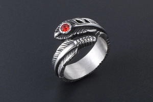 Detail view of gothic feather ring in stainless steel with a round red gemstone