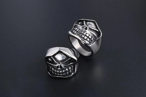 Macro detail of gothic skull head rings in matte silver steel with grim reaper design