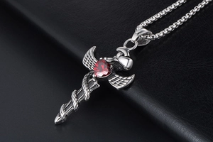 Macro shot of gothic angel sword pendant with red heart stone and intricate snake detail