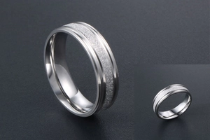 Macro shot of silver titanium steel ring with frosted glitter inlay and polished edges
