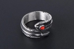 Macro detail of gothic feather ring in titanium steel with a red rhinestone accent