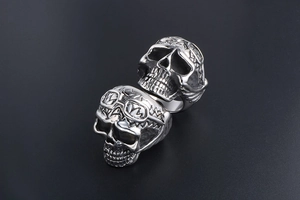 Macro detail of punk skull rings with intricate metal textures and goggles in retro silver