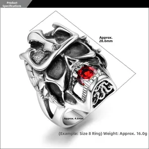 Detail of silver skull ring with red gemstone eye and gothic crown carving