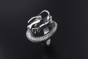 Detailed macro view of the intricate dragon scale textures on the vintage steel ring