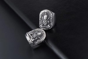 Detailed macro shot of vintage silver Ganesha relief on a stainless steel ring