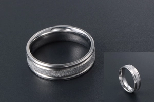 Macro detail of silver titanium steel ring featuring frosted texture and polished edges