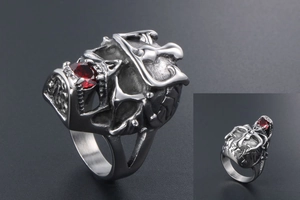 Detailed macro view of gothic silver skull ring with a faceted red gemstone inlay