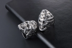 Detail view of retro mummy skull punk rings in vintage steel finish on black leather