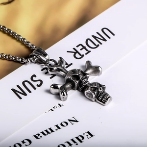 Punk vintage titanium steel double skull cross pendant necklace on a white magazine