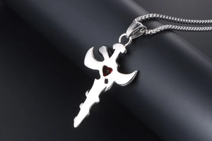 Detail shot of vintage titanium steel sword pendant with a red heart-shaped gemstone