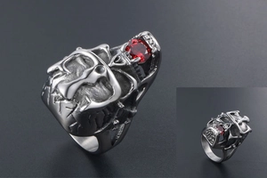 Macro detail of gothic skull ring featuring a crown and central red gemstone inlay