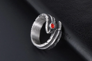 Macro detail of gothic titanium steel feather ring with a bright red cubic zirconia stone