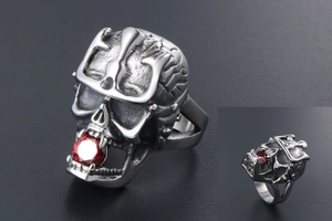 Macro detail of gothic skull ring with crown and red zircon stone in vintage steel