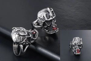 Macro detail of gothic skull ring with crown carving and a red gemstone inlay