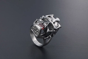 Macro view of gothic skull crown ring with red pear-cut gemstone in vintage steel finish