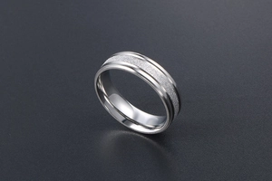 Macro detail of silver titanium steel ring with sandblasted finish and polished edges