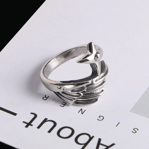 Gros plan sur la bague aile d'ange en acier titane pour homme avec détails de plumes