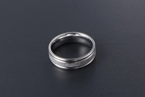 Detail of matte sandblasted texture and polished edges on a silver titanium steel ring