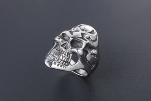 Detailed close-up of a punk style silver skull ring with vintage steel texture