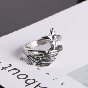 Gros plan sur la bague ailes d'ange en argent avec motif d'étoile et aspect vintage
