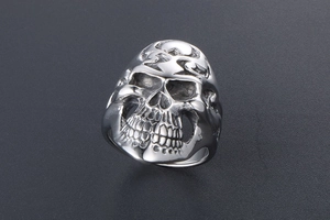 Macro shot of a vintage gothic skull ring with intricate flame carvings in silver steel