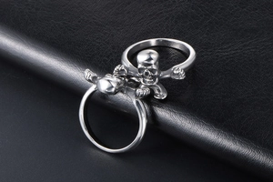 Close-up of double finger stainless steel skull ring with punk aesthetic on leather background
