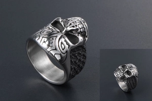 Macro view of vintage skull ring showing detailed 3D relief and textured steel band