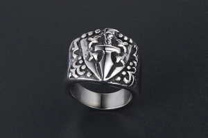 Detailed close-up of gothic shield ring with dagger and iris engravings in vintage steel