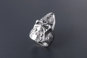 Macro detail of silver punk skull ring showing textured bones and oxidized steel finish