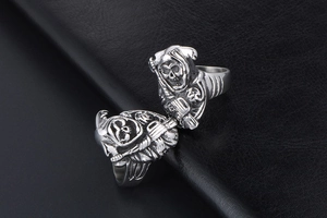 Detailed close-up of 3D Grim Reaper skull rings on black leather in punk gothic style