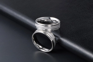 Close-up of titanium steel couple rings with matte center and polished edges on leather