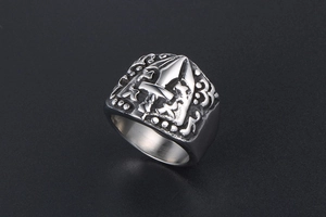 Macro detail of gothic signet ring with engraved cross and sword design on vintage steel