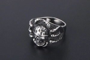 Macro detail of men's punk skull ring with gothic dragon claw design and vintage finish