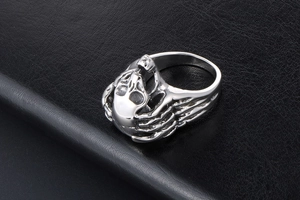 Detailed top view of punk skull ring with skeletal bone carvings on black leather
