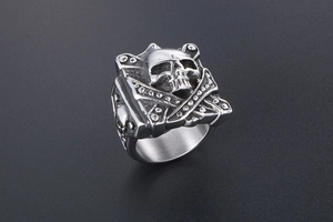 Close-up of gothic square skull ring with crossbones and rivets in polished steel