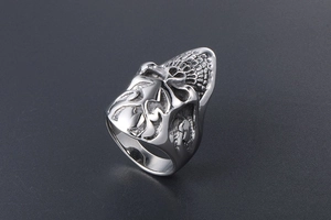 Macro shot of silver gothic skull ring featuring intricate embossed textures and punk style