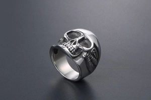Macro de bague tête de mort argentée punk avec gravures d'ailes gothiques sur acier
