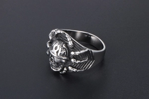 Macro view of a punk skull ring showing detailed rib cage carvings and silver finish