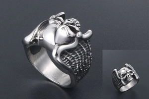 Macro shot of silver stainless steel skull ring with angel wings and mesh texture detail