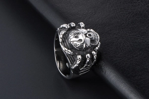 Macro view of vintage skull ring with intricate gothic spider limb textures on black leather