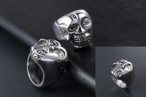 Détail de la bague gothique en acier avec relief de visage et crâne sculpté