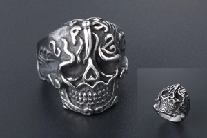 Macro view of vintage stainless steel skull ring with intricate baroque cloud carvings