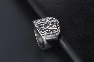 Close-up of vintage silver stainless steel ring featuring a detailed nautical anchor relief