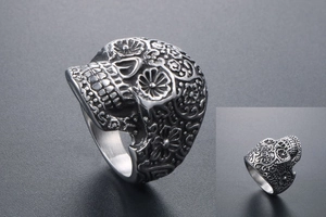 Detailed macro view showing the intricate floral carvings on the silver punk skull ring