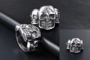 Macro detail of gothic skull ring with three skulls in vintage polished titanium steel