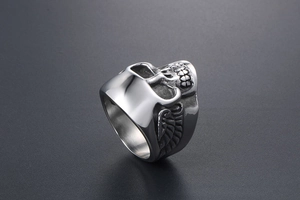 Détails d'une bague tête de mort punk vintage avec ailes sculptées et finition argentée